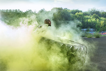 Image showing Handsome muscular man flipping big tire outdoor.