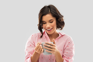 Image showing happy young woman in pajama with mug of coffee