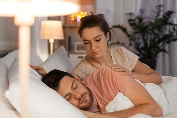 Image showing woman wakes her sleeping husband up in bed at home