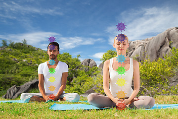 Image showing couple doing yoga in lotus pose with seven chakras