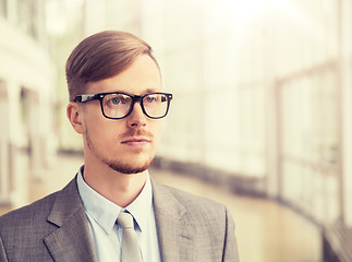 Image showing young businessman in suit and glasses at office