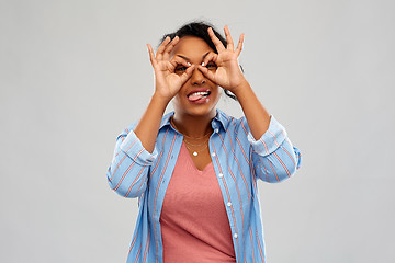 Image showing african woman looking through finger glasses