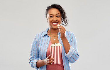 Image showing happy african american woman eating popcorn