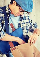 Image showing close up of hipster man looking into his bag