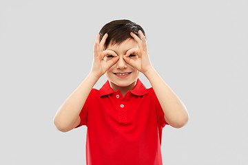 Image showing boy in red t-shirt looking through finger glasses