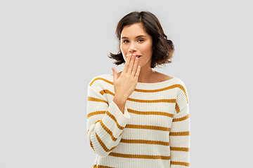 Image showing happy woman covering mouth by hand and giggling