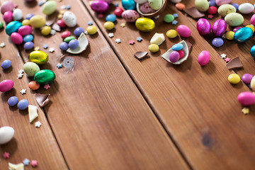 Image showing chocolate eggs and candy drops on wooden table