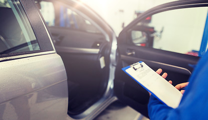 Image showing auto mechanic man with clipboard at car workshop