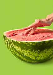 Image showing Woman\'s fingers inside fresh juicy natural watermelon\'s pulp.