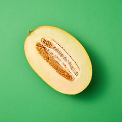 Image showing Half of fresh ripe sweet melon on a seagreen background.