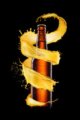 Image showing Glass bottle with spiral beer splash.