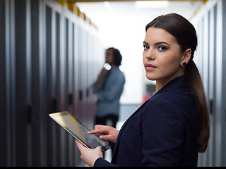 Image showing Female engineer working on a tablet computer in server room