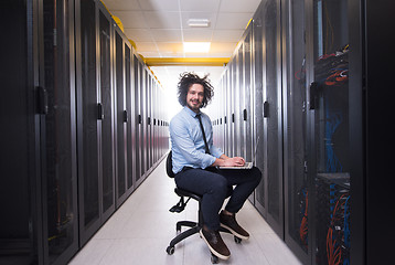 Image showing engineer working on a laptop in server room