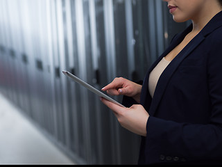 Image showing Female engineer working on a tablet computer in server room