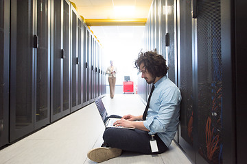 Image showing Team of young technicians working together on servers