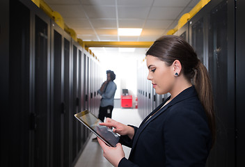 Image showing Female engineer working on a tablet computer in server room