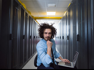 Image showing engineer working on a laptop in server room