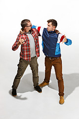 Image showing Two friends in casual colorful wear standing and laughing together.