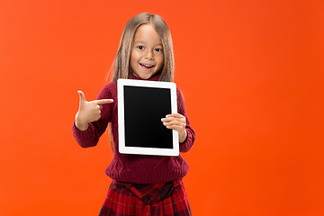 Image showing Little funny girl with tablet on studio background