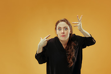 Image showing Beautiful female half-length portrait isolated on studio backgroud. The young emotional surprised woman