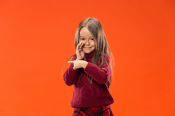 Image showing The young teen girl whispering a secret behind her hand