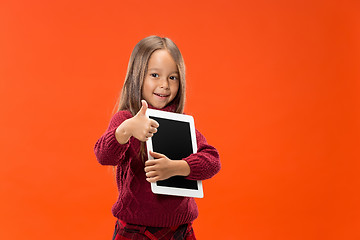 Image showing Little funny girl with tablet on studio background