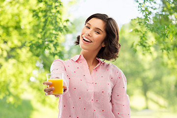 Image showing happy young woman in pajama holding orange juice