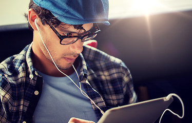 Image showing close up of man with tablet pc and earphones
