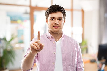 Image showing young man showing one finger over office