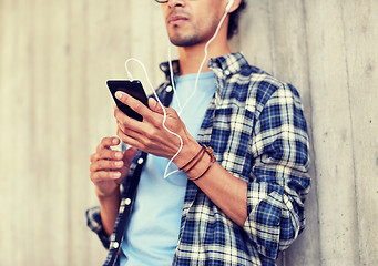 Image showing man with earphones and smartphone listening music