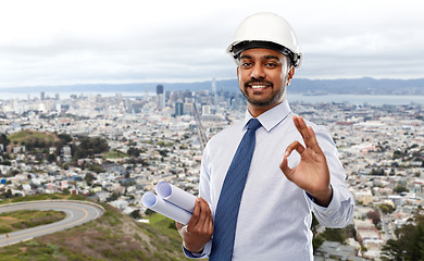 Image showing architect in helmet with blueprints showing ok