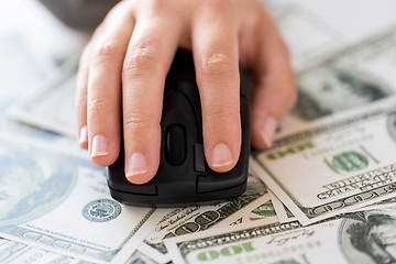 Image showing close up of hand with computer mouse on money