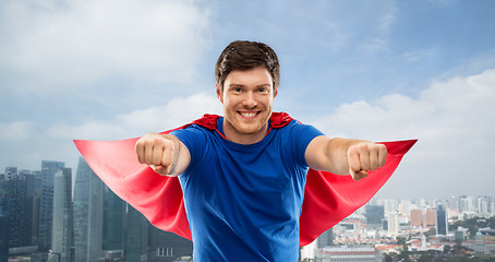 Image showing man in red superhero cape over singapore city