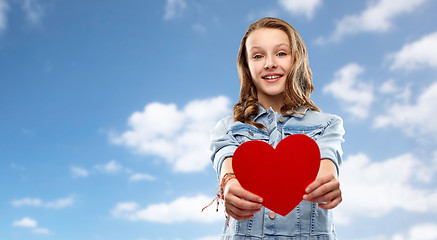 Image showing smiling teenage girl with red heart over sky