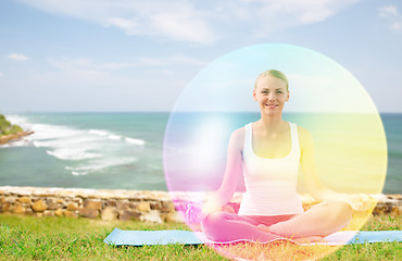 Image showing woman doing yoga in lotus pose with rainbow aura