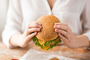 Image showing close up of woman holding hamburger