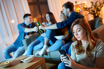 Image showing sad young woman with smartphone at home party