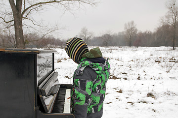 Image showing Boy playing piano outdoors