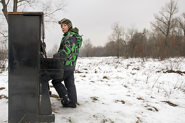 Image showing Boy playing piano outdoors