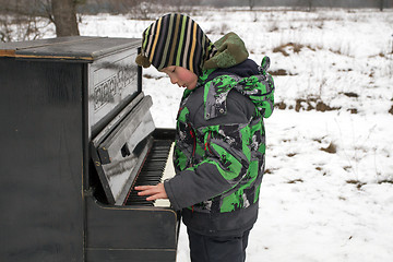 Image showing Boy playing piano outdoors