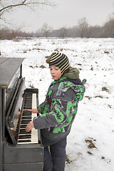 Image showing Boy playing piano outdoors