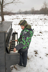 Image showing Boy playing piano outdoors