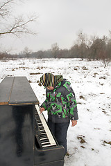 Image showing Boy playing piano outdoors