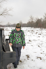 Image showing Boy playing piano outdoors