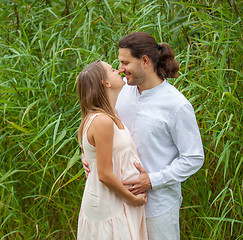 Image showing  A man and a pregnant woman in a park