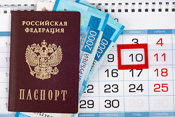 Image showing View from above on the calendar on which lies a passport with 2,000 ruble banknotes