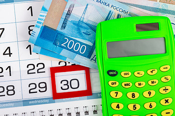 Image showing Calendar with a allocated 30 number, Russian two-thousand bills, calculator