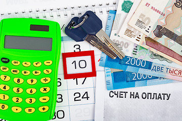 Image showing Calendar with the number 10, calendar, calculator, bunch of keys and a pack of Russ rubles, and the invoice