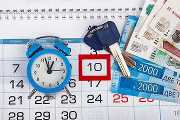Image showing The calendar, there is an alarm clock, money and keys to the apartment