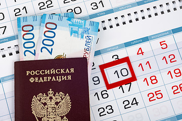 Image showing Russian passport with banknotes two thousand rubles are on the calendar with a dedicated date tenth number